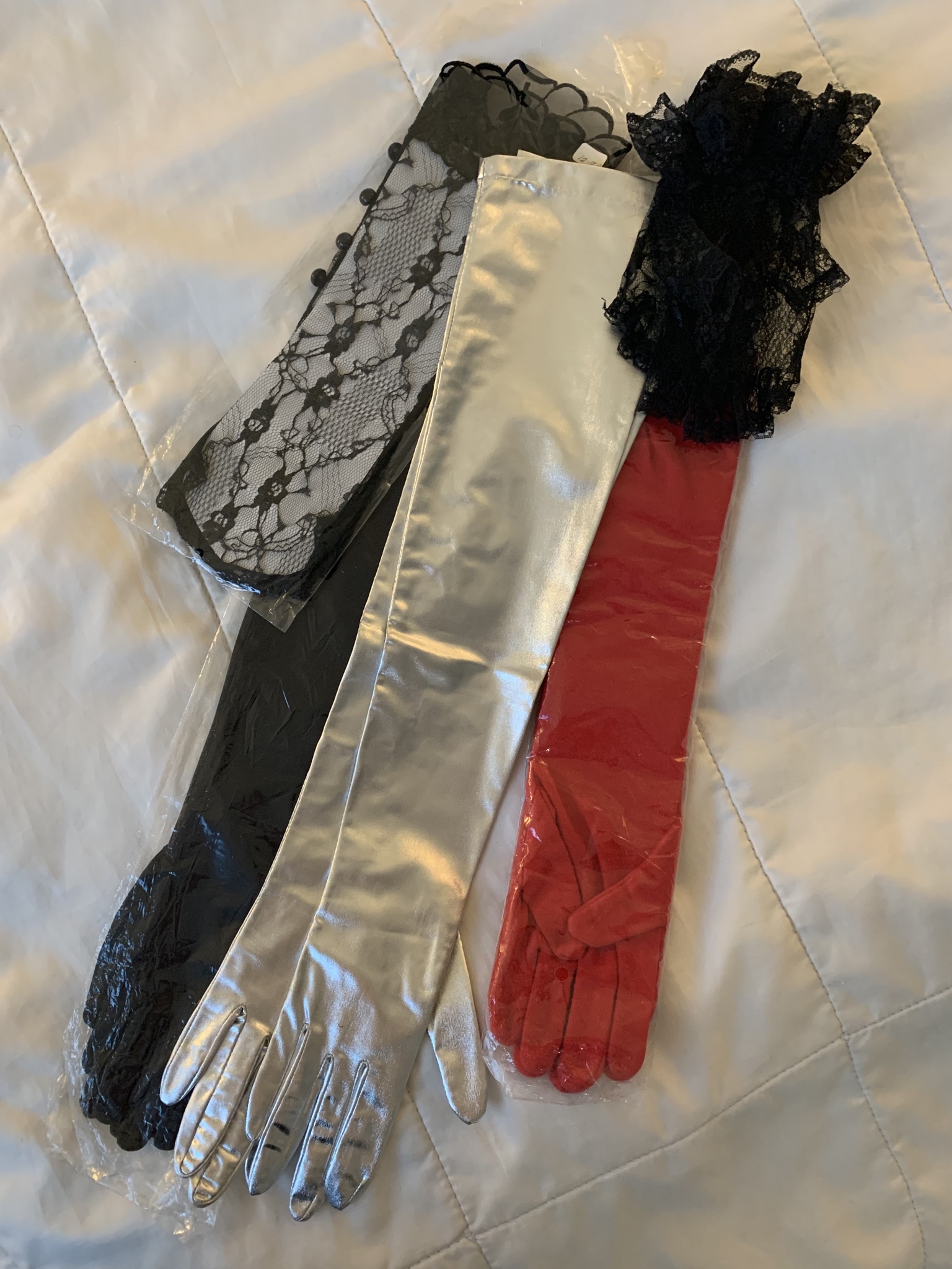 And yet another five pairs of gloves laid out, two black lacy pairs, and three fancy elbow length pairs in black, silver, & red.
